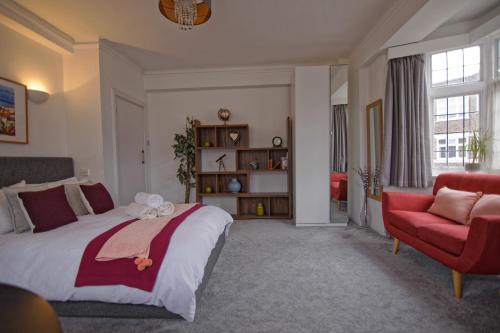 ロンドンにあるArrondissement Bloomsburyのベッドルーム1室(大型ベッド1台、赤い椅子付)