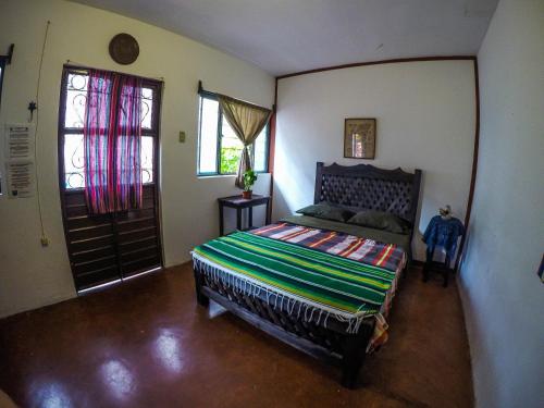 a bedroom with a bed and a window and a door at Hostel El Nagual in San Cristóbal de Las Casas