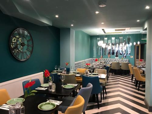 a restaurant with tables and chairs and a green wall at Amazing London in London