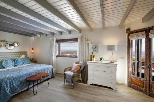 ein Schlafzimmer mit einem Bett, einer Kommode und einem Fenster in der Unterkunft Deluxe designer historic villa Via Lactea, Panoramic sea views, Own private heated pool and subtropical garden in La Asomada