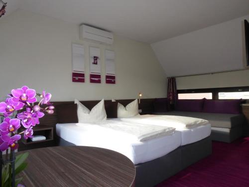 um quarto com uma cama, um sofá e flores em Pension am Weinberg Bed & Breakfast em Mainstockheim