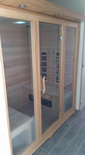 a wooden cabinet with glass doors in a room at Chambre d'hôtes source de la St Baume in Plan dʼAups