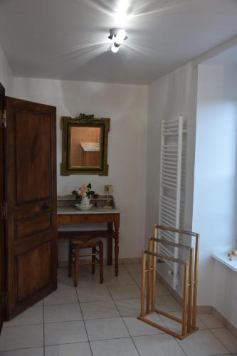 Cette chambre comprend un bureau, un miroir et une table. dans l'établissement Gîtes de la Croix du Bourg, à Le Mesnil-Ozenne