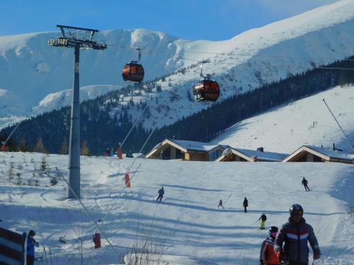a group of people on a ski slope with a ski lift at Pod Dubom in Liptovský Mikuláš