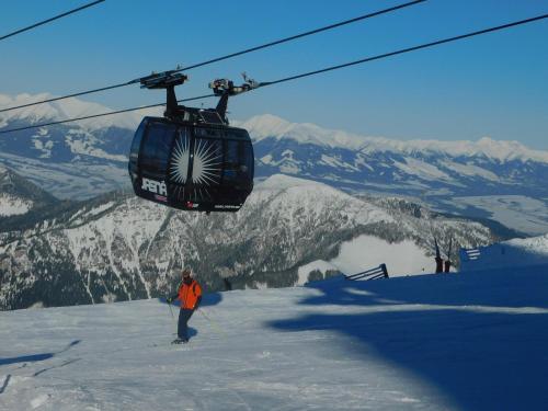 a person standing on a ski slope under a ski lift at Pod Dubom in Liptovský Mikuláš