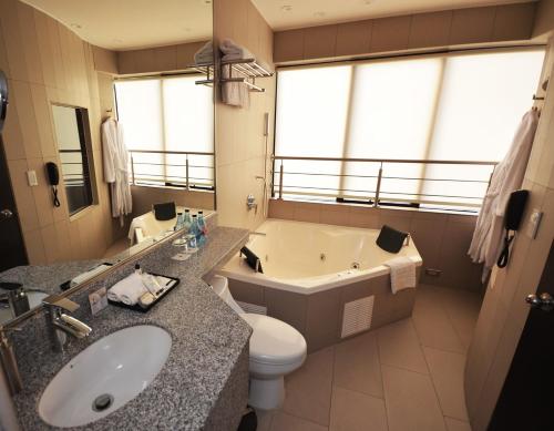 e bagno con vasca, servizi igienici e lavandino. di qp Hotels Lima a Lima