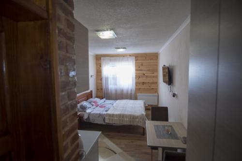 a small bedroom with a bed and a window at Durmitorske zore in Žabljak