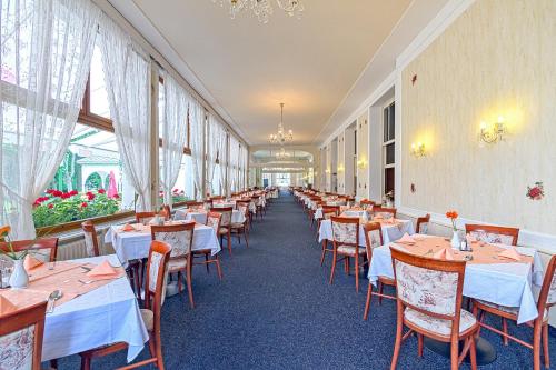 a row of tables and chairs in a restaurant at Belvedere Spa & Kurhotel in Františkovy Lázně