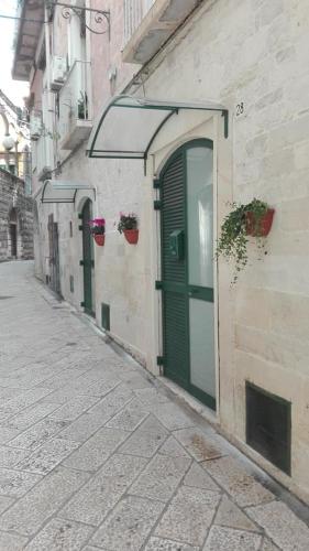 eine Gasse mit grünen Türen an einem Gebäude in der Unterkunft Dimora Termite Pietà in Bitonto