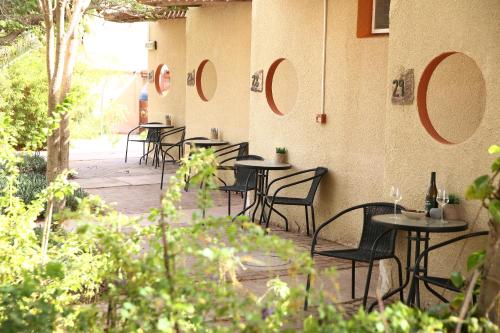 a row of tables and chairs on a patio at קיבוץ אילות - חדרי אירוח עם בריכה משותפת in Eilat