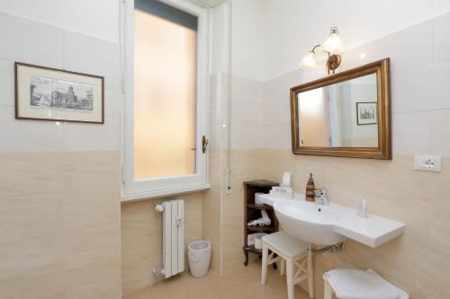 y baño con lavabo y espejo. en Appartaments Marrucini, en Roma