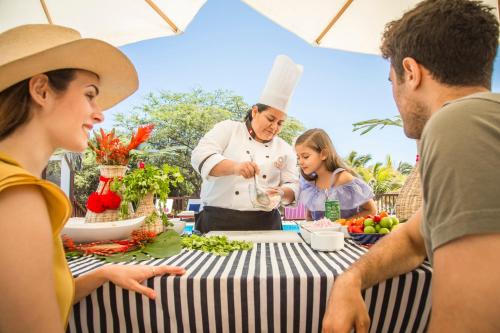 a group of people standing around a table with a chef at Vichayito Bungalows & Carpas by Aranwa Hotels in Vichayito