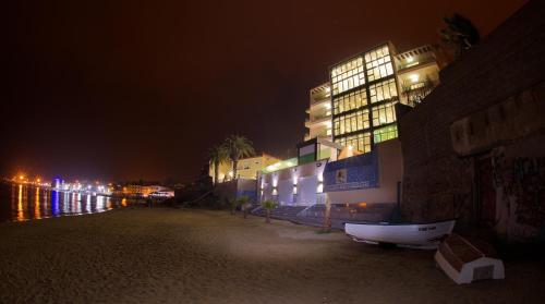 a building is lit up at night next to the water at RESIDENCE TOURISTIQUE DU PORT in Alger