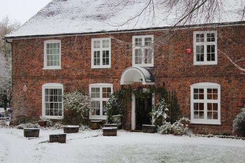 a brick house with snow on the ground at Molland Manor House Bed & Breakfast in Sandwich