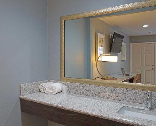 a bathroom with a sink and a large mirror at Del Mar Motel in Rosemead