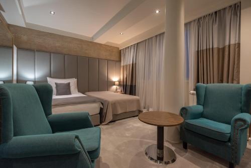 ein Hotelzimmer mit einem Bett, 2 Stühlen und einem Tisch in der Unterkunft Hotel ABC in Leskovac