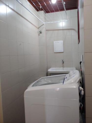 um pequeno banheiro com um vaso sanitário e uma pia em Ótimo apartamento na Prainha Torres/RS em Torres