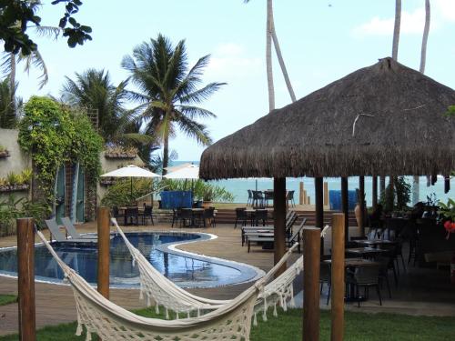 a resort with a hammock and a swimming pool at Flor de Lis Exclusive Hotel in Maceió