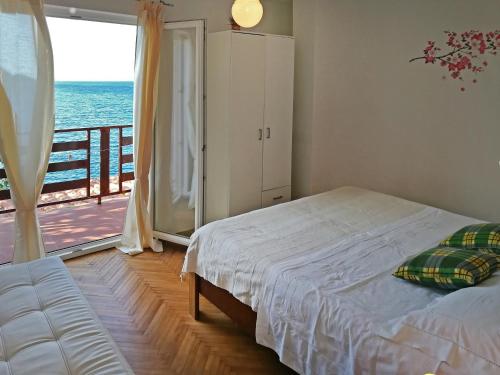 a bedroom with a bed and a view of the ocean at Apartment Šime Savar in Savar