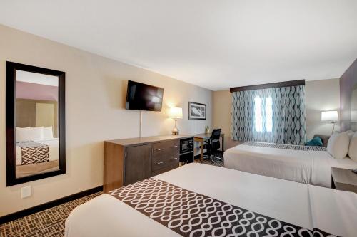 a hotel room with two beds and a mirror at La Quinta Inn & Suites by Wyndham Las Vegas Nellis in Las Vegas