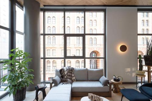 a living room with a couch and a large window at ROOST East Market in Philadelphia
