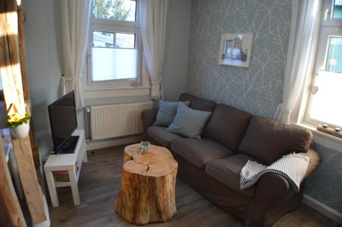 a living room with a couch and a tree stump coffee table at Ferienwohnung "Auszeit" in Tabarz