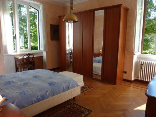 1 dormitorio con cama y espejo en Casa Raffaello, en Castelletto sopra Ticino