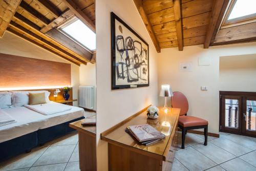 a bedroom with a bed and a desk in a room at Appartamenti La Grotta in Bardolino