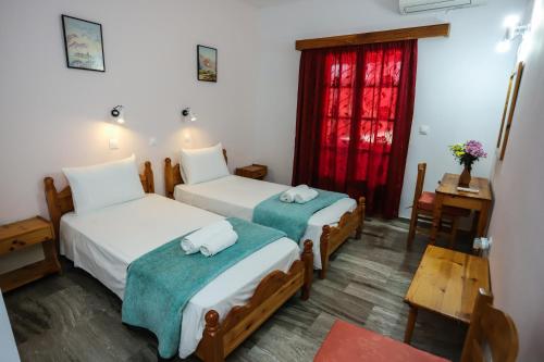 a hotel room with two beds and a window at Marianna House in Agios Georgios Pagon