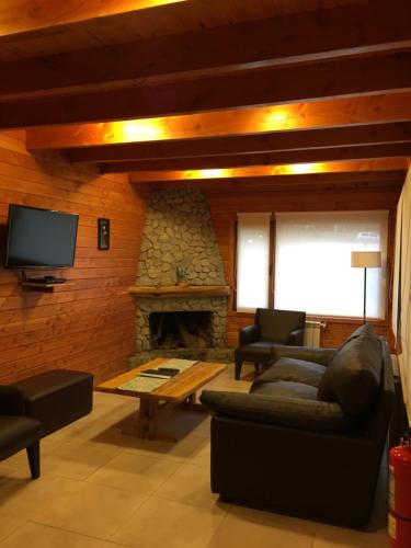 a living room with a couch and a fireplace at Encanto del Rio in Villa La Angostura