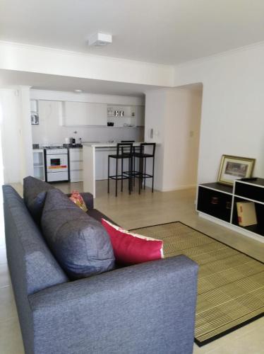 a living room with a couch and a kitchen at garden33 in Chivilcoy