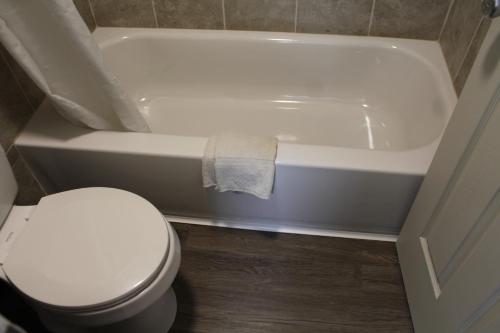 a bathroom with a toilet and a white bath tub at Regency Inn in Rolla