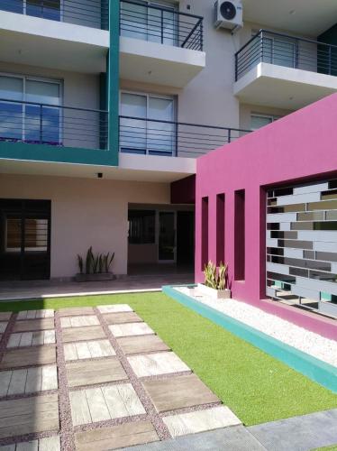 a pink house with a yard in front of it at garden33 in Chivilcoy