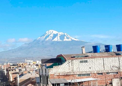 a snow covered mountain in the background of a city at La Merced Plaza Hospedaje in Riobamba