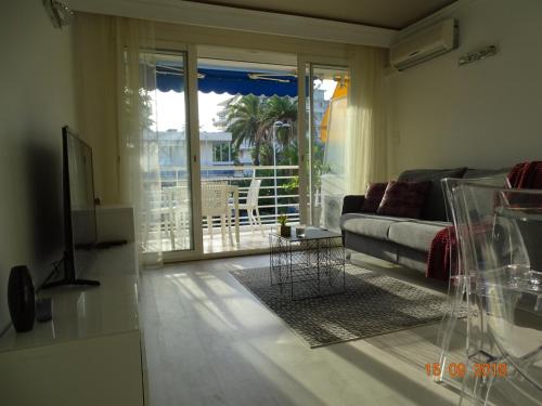 a living room with a couch and a sliding glass door at Palm beach Cannes Azur in Cannes