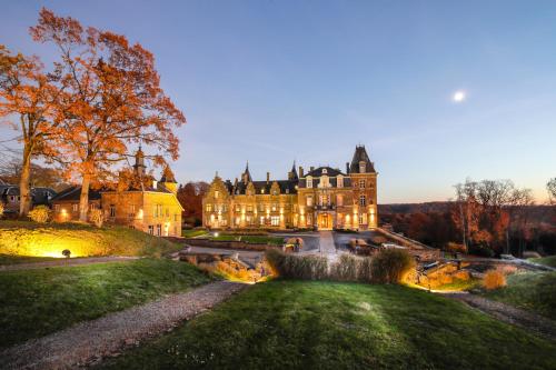 a large mansion with a fountain in front of it at Domaine de Ronchinne - Château et Ecuries in Maillen