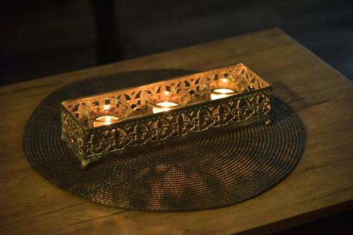 a candle holder sitting on a table with a plate at Apartman Sladjana Premier 12 Milmari in Kopaonik
