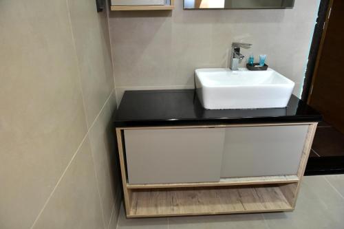 a bathroom with a white sink and a mirror at Apartman Sladjana Premier 12 Milmari in Kopaonik