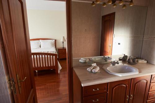 a bathroom with a sink and a mirror and a bed at Vivenda da Saudade B&B in Angra do Heroísmo