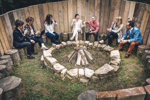 a group of people sitting around a fire pit at Domaine de Ronchinne - Château et Ecuries in Maillen