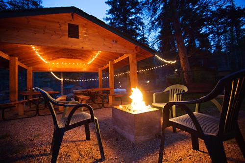 a fire pit with chairs and a pavilion with lights at Idlewilde by the River in Estes Park