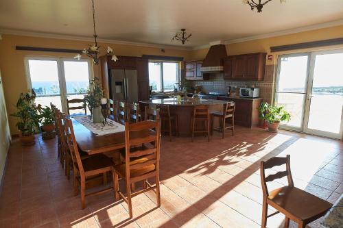 a kitchen and dining room with a table and chairs at Vivenda da Saudade B&B in Angra do Heroísmo