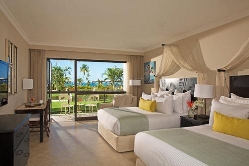 a hotel room with two beds and a balcony at Dreams Playa Bonita All Inclusive in Playa Bonita Village