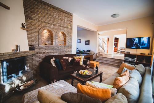 a living room with a couch and a fireplace at Villa Soula in Anavissos