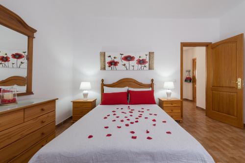Un dormitorio con una cama con rosas rojas. en Apartamentosánchez en Vecindario