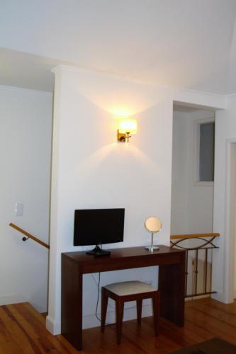 a room with a desk with a monitor and a stool at Guest house Santa Maria in Funchal