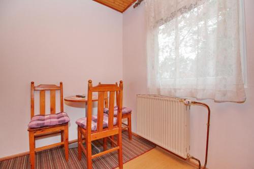 a room with two chairs and a table and a window at Vila As in Zlatibor
