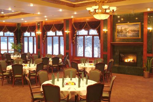 a dining room with tables and chairs and a fireplace at Pike's Waterfront Lodge in Fairbanks