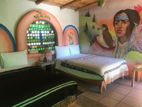 1 dormitorio con 2 camas y un cuadro en la pared en Rancho Cabañas San Isidro en Cerocahuí