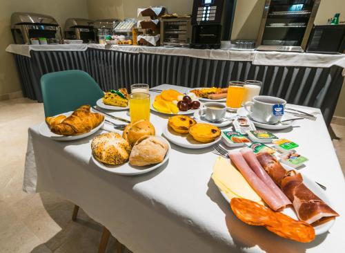 uma mesa coberta com pratos de alimentos e bebidas em Rossio Boutique Hotel em Lisboa